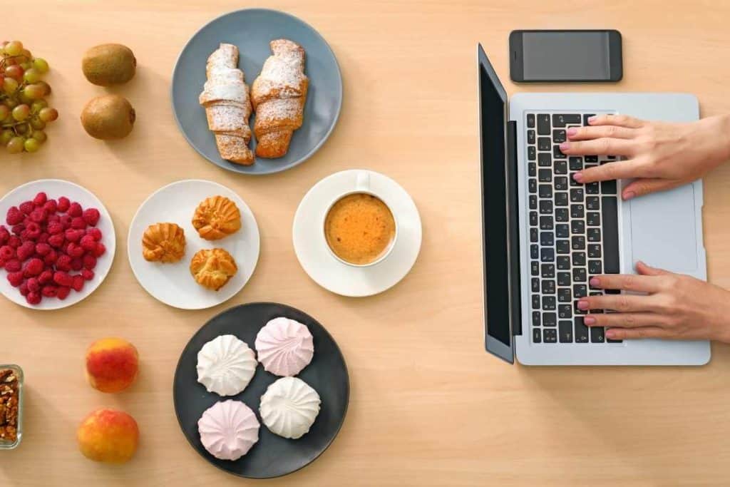 How to Start a Food Blog plates of various foods with a laptop