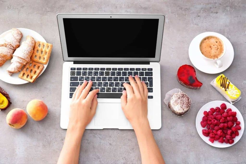 Make Money with a Food Blog laptop and plates of various foods